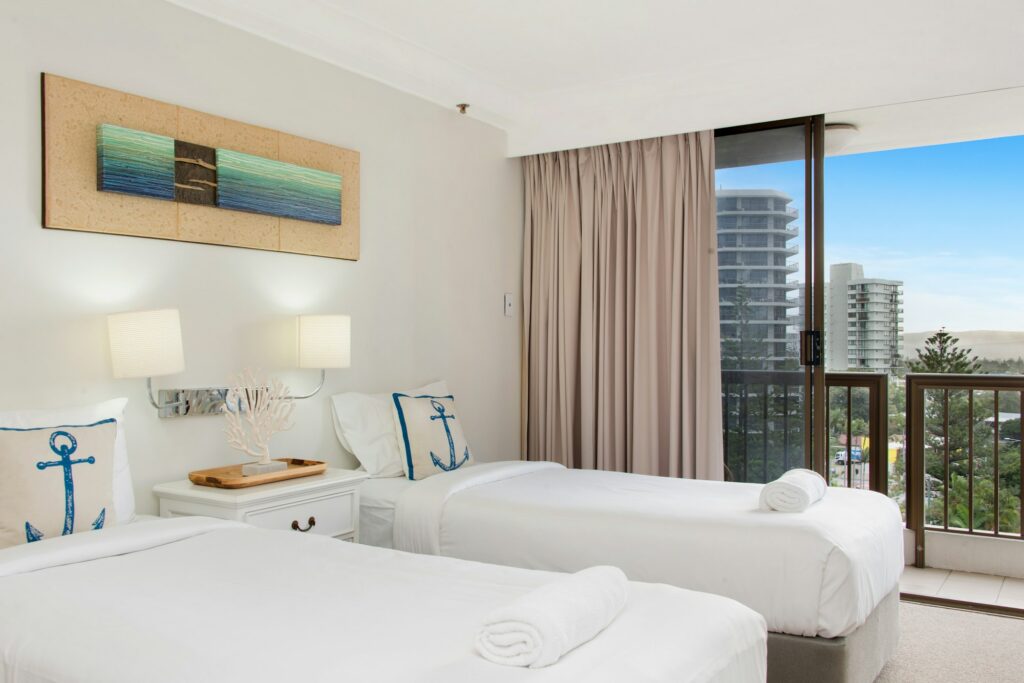 Guest room with two beds and a balcony door