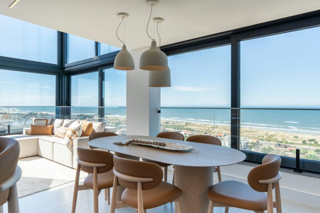 Dining table with a wall of windows facing the beach