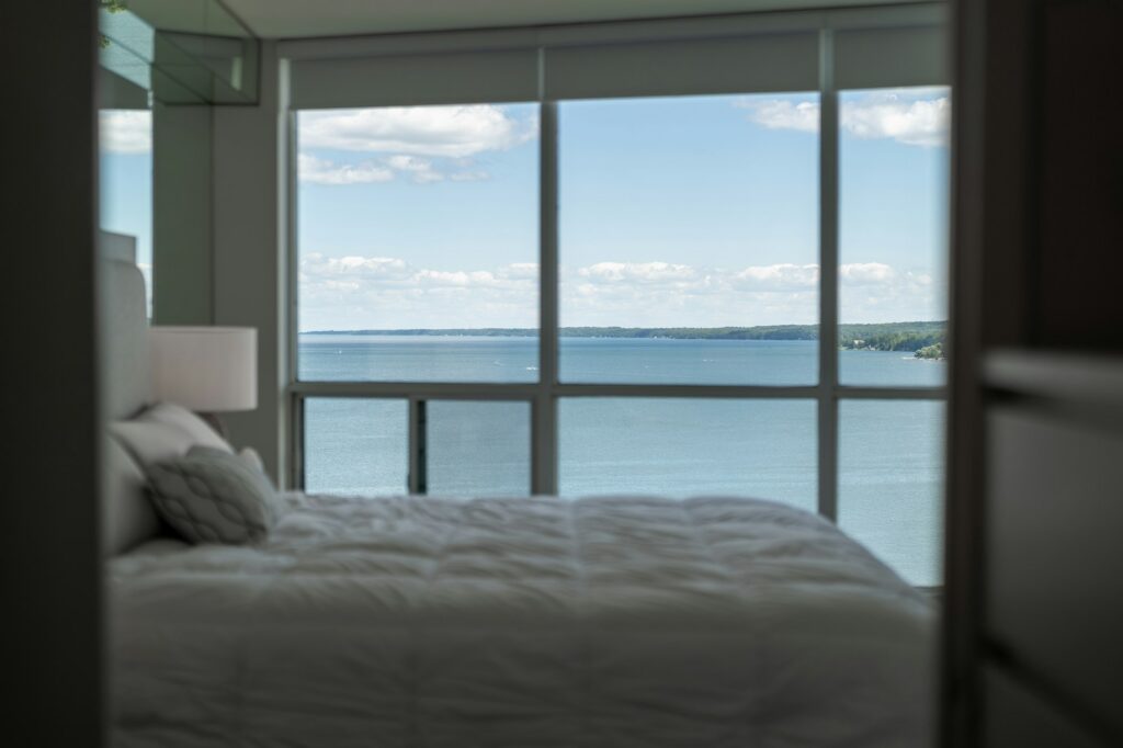 Primary bedroom with a wall of windows over the water