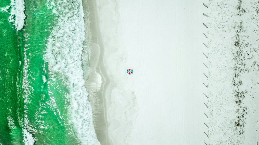 Aerial view of white sand meeting green water